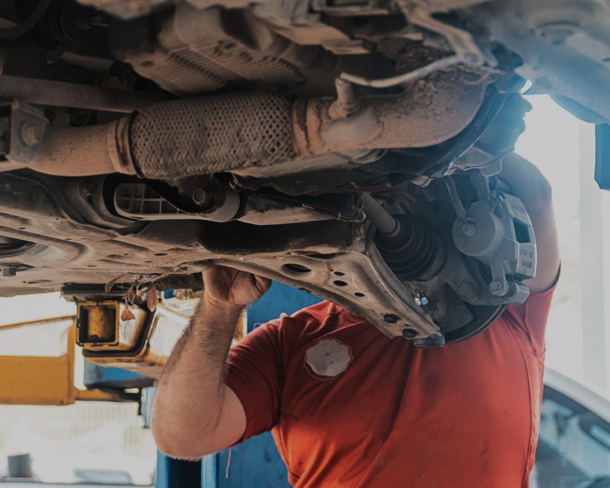 Kfz-Mechaniker bei Reparaturarbeiten am Unterboden